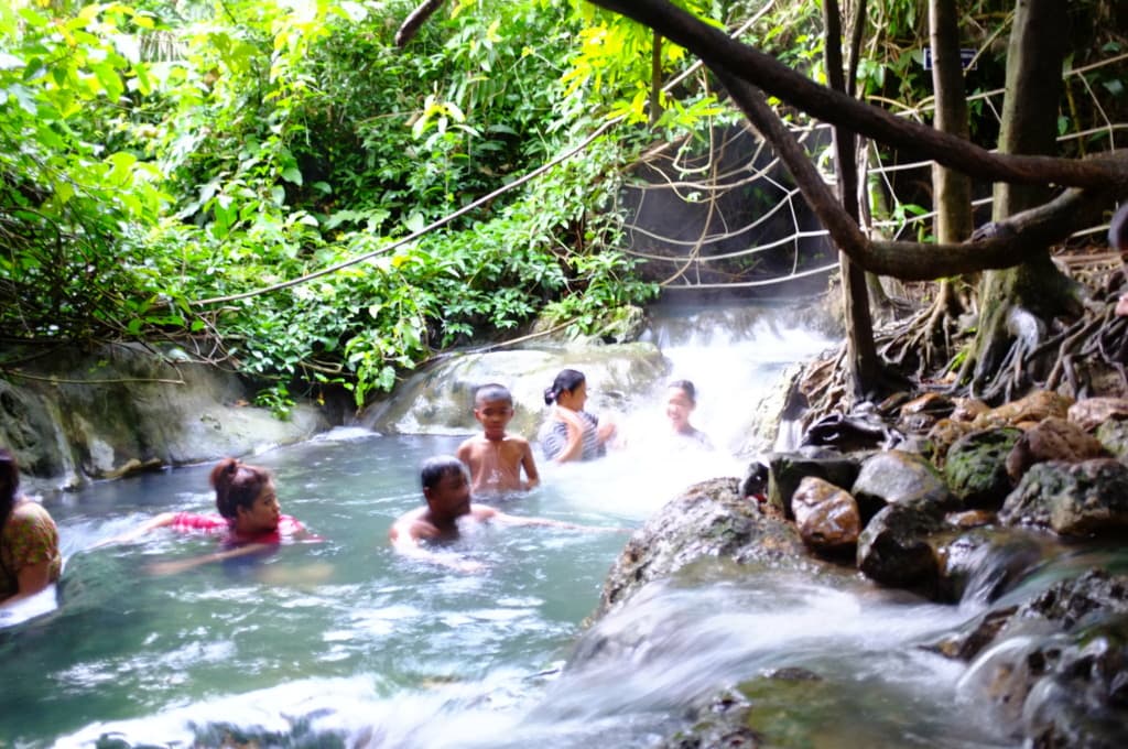 People swimming in Klong Thom Hot Springs in Krabi, Thailand