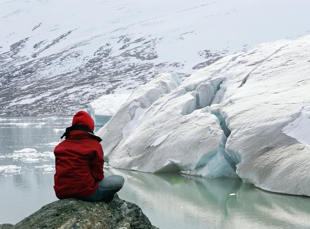 A girl looks on a glacier