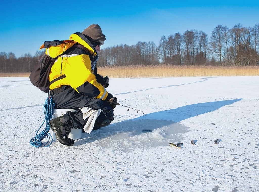 A man ice fishing in Alaska in winter
