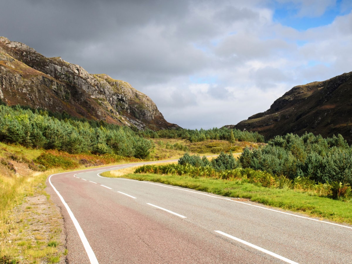 A road runs through mountain crags at Lochcarron in Scotland