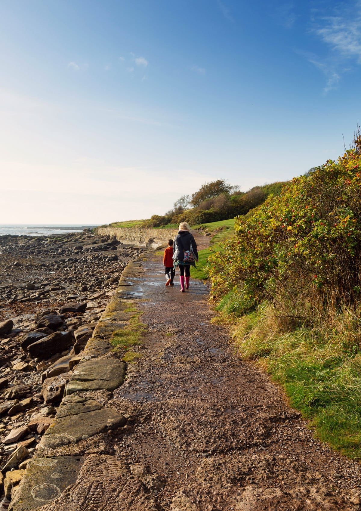 A mother and her son walking along a coastal path in Crail, Fife, Scotland