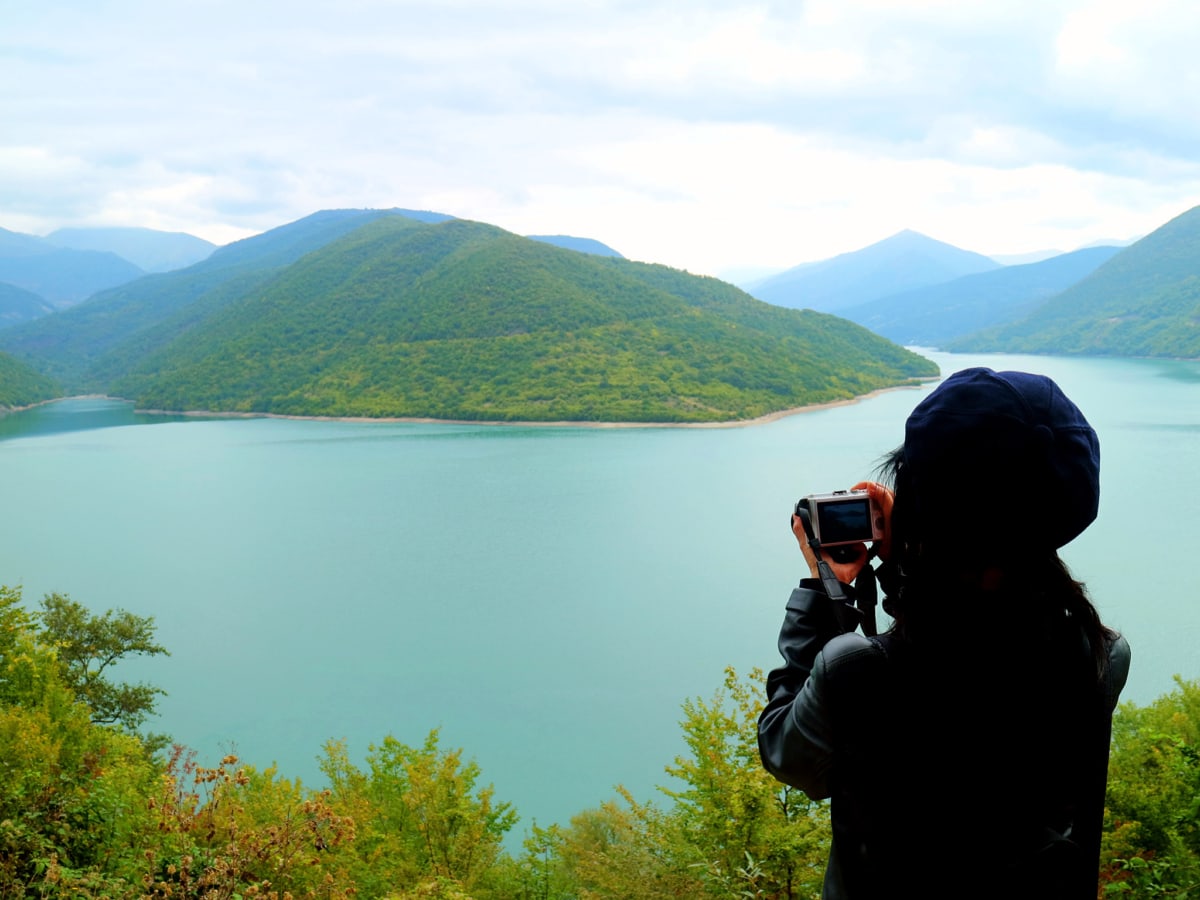 A hiker taking photos at the Jinvali water reservoir in Georgia