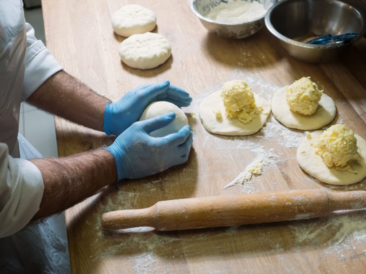 A professional cook making khachapuri with cheese