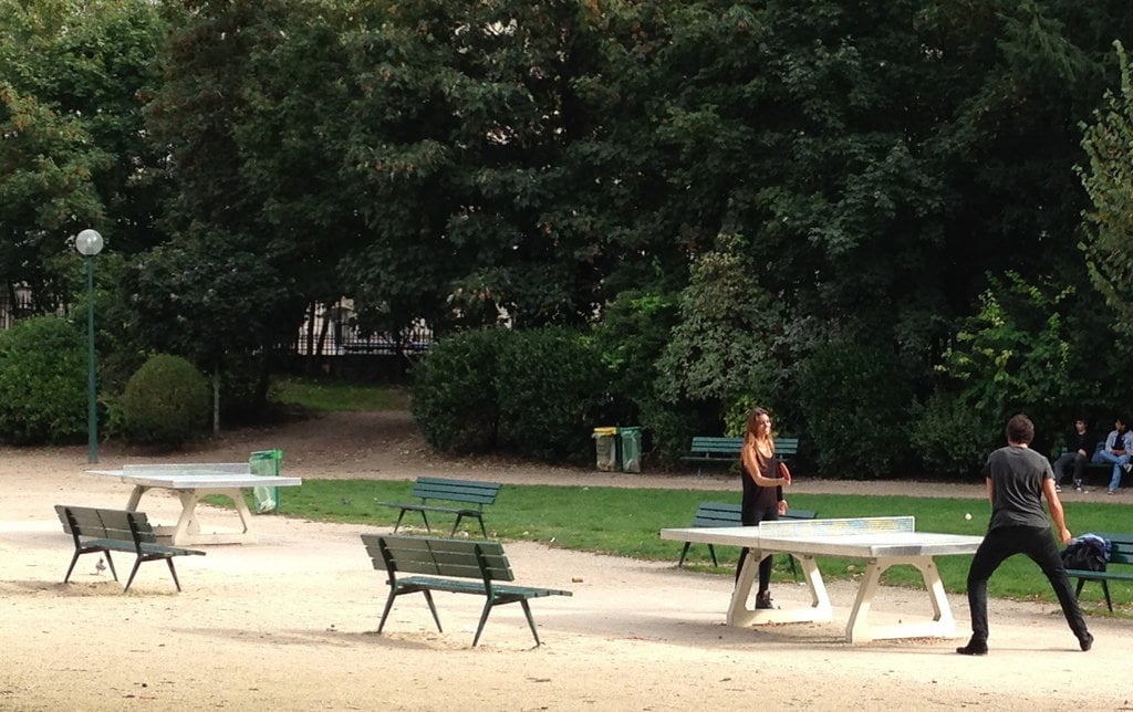 A couple playing Ping-Pong at a Park in Paris