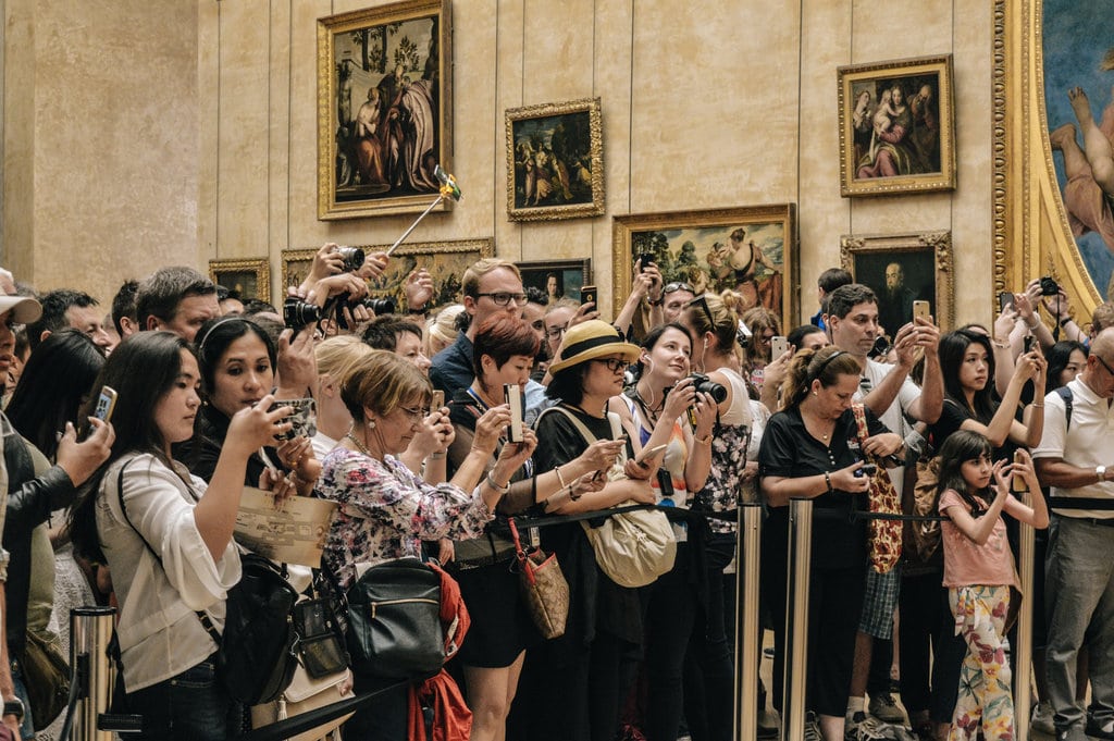 Tourists taking photo of Mona Lisa painting in the Louvre museum