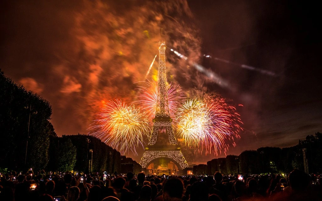 Bastille Day fireworks in Paris, people watchinng from Champ de Mars in front on the Eiffel Tower
