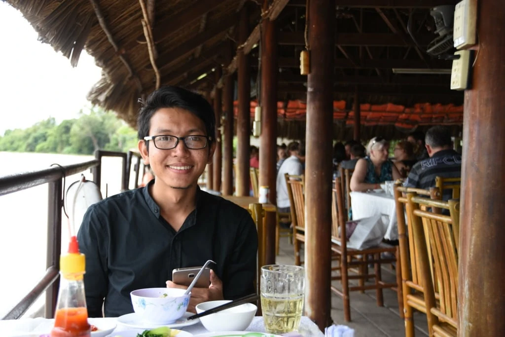 Man eating in the restaurant on the waterfront of the Saigon River in Ho Chi Minh