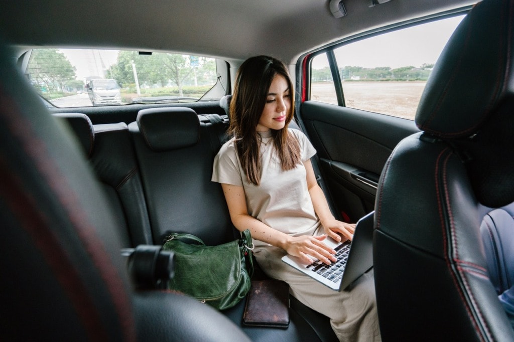 Woman Using Laptop Computer Inside Vehicle