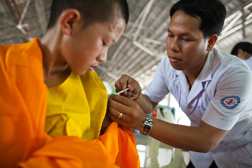 A male nurse administering flu vaccine to young man