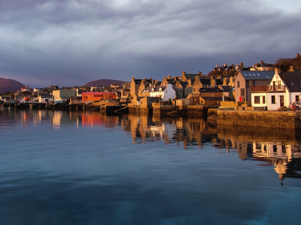 Waterfront view of houses and hill in Orkney harbour town of Stromness