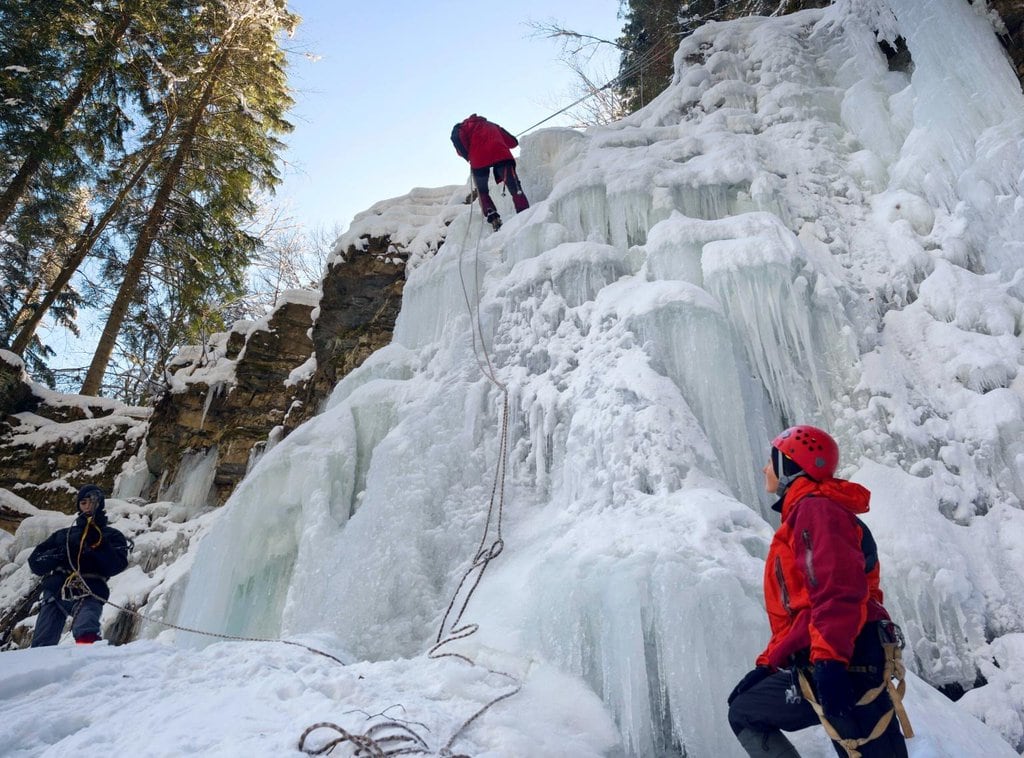 A group of people ice climbing in winter